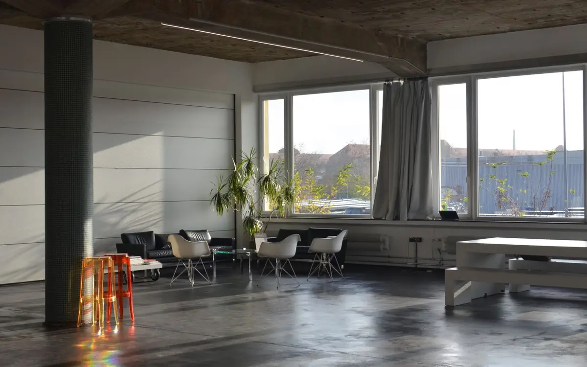 Loft met een naadloze grijze gietvloer en grote ramen